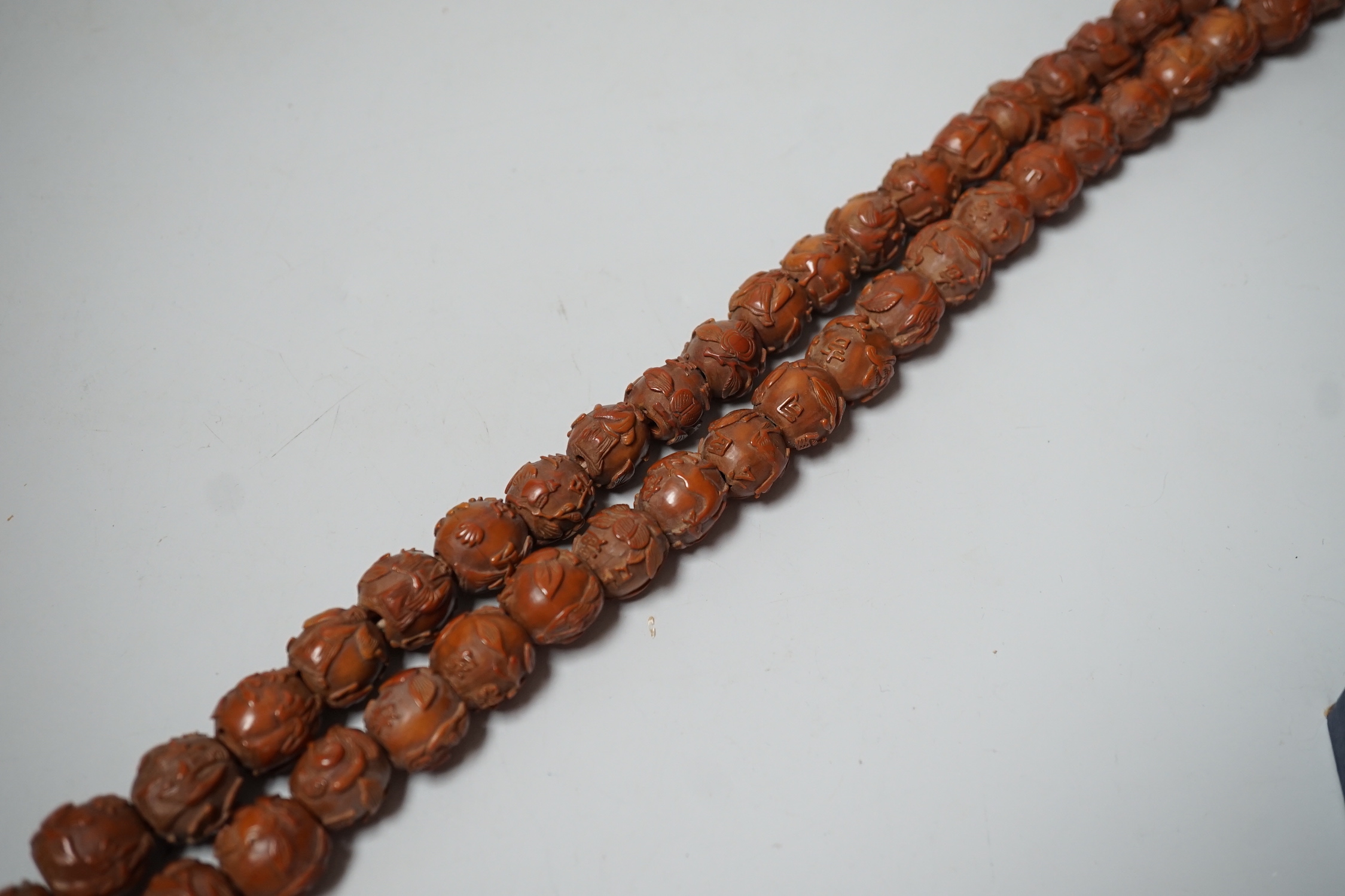 A Chinese necklace of 94 carved coquilla nuts/peach stones